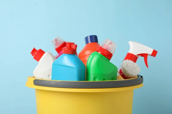 Cubo con detergente y artículos de limpieza sobre fondo azul , —  Fotos de Stock