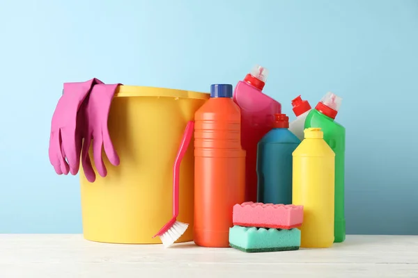 Cubo, botellas con detergente y artículos de limpieza en bac azul —  Fotos de Stock