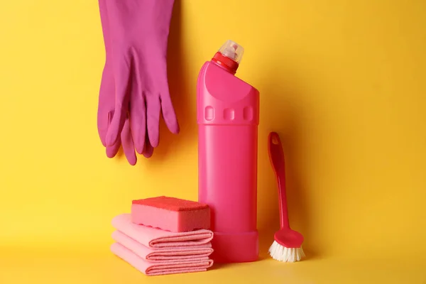 Botella con detergente y artículos de limpieza sobre fondo amarillo —  Fotos de Stock