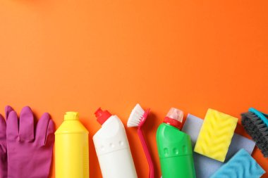 Deterjanlı şişeler ve turuncu sırtüstü temizlik malzemeleri.