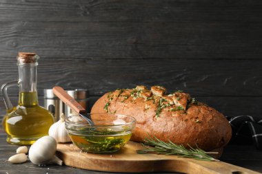 Ahşap zemin üzerinde sarımsaklı ekmek ve yağ bulunan tahta, 