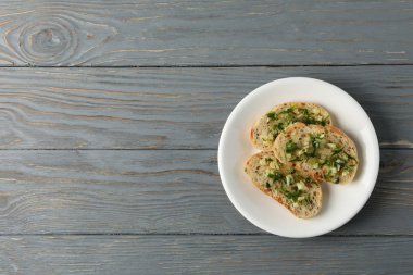 Ahşap zemin üzerinde kızarmış sarımsaklı ekmek tabağı.