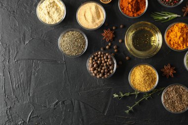 Siyah arka planda farklı baharat ve malzeme içeren kaseler.,
