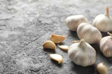 Sarımsak soğanları, gri arkaplanda dilimler, metin için boşluk