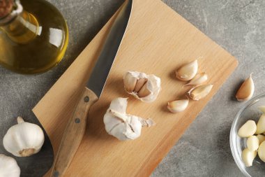 Sarımsak soğanları, dilimler, yağ, bıçak, gri ahşap sırt grubunda tahta
