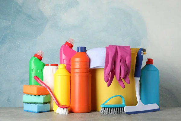 Botellas con detergente y artículos de limpieza sobre fondo azul , —  Fotos de Stock