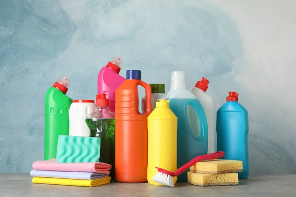 Botellas con detergente y artículos de limpieza sobre fondo azul , —  Fotos de Stock