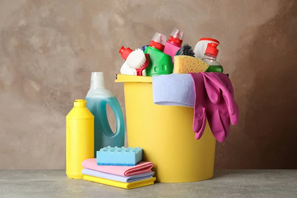 Botellas con detergente y artículos de limpieza sobre fondo marrón —  Fotos de Stock