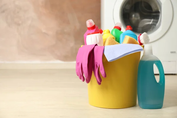 Bucket with detergent and cleaning supplies on brown background, — Stock Photo, Image