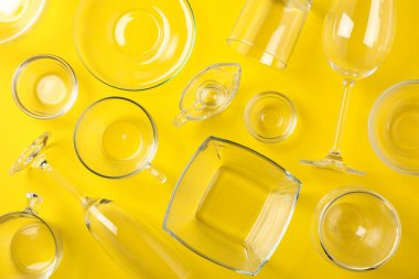 Sarı arka planda kaseler, bardaklar ve bardaklar, üst manzara