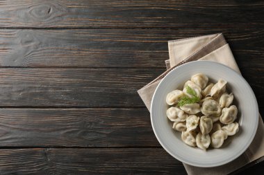 Ahşap zemin üzerinde hamur tatlısı olan havlu ve tabak.