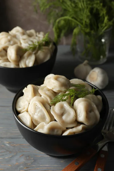 Bowls with dumplings on wooden table, close up — Stock Photo, Image