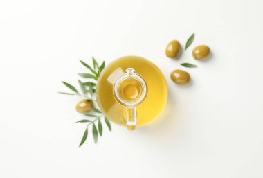 Zeytinyağlı sürahi, beyaz arka planda zeytin ve yapraklar, en üstte v