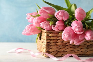 Mavi zemin üzerinde laleler olan sepet, kapat.