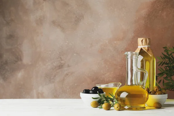 Složení s olivovým olejem a olivami na hnědém pozadí, — Stock fotografie