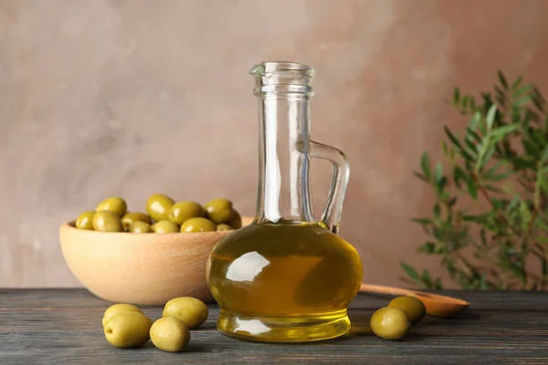 Skład z oliwą z oliwek i oliwkami na drewnianym stole, zbliżenie — Zdjęcie stockowe