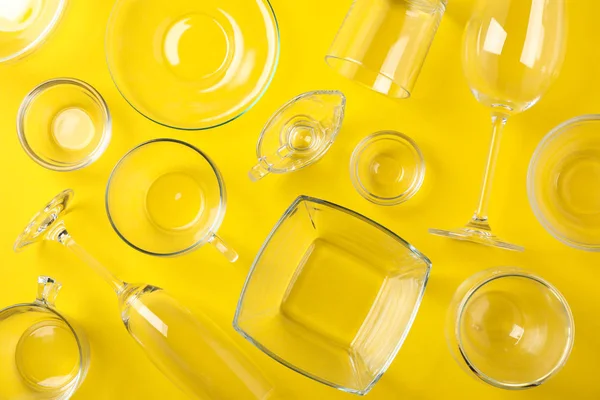 Sarı arka planda kaseler, bardaklar ve bardaklar, üst manzara