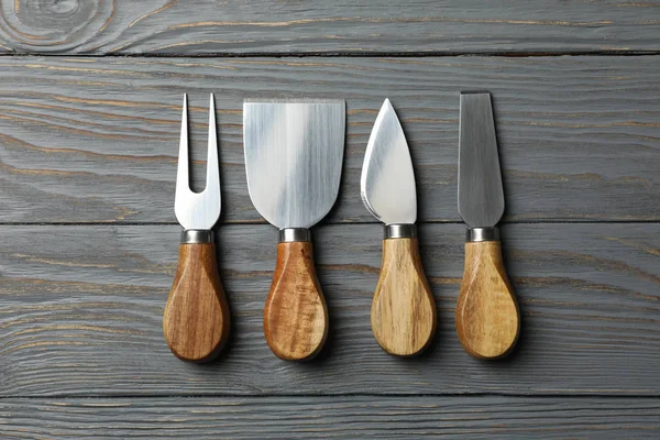 Cheese knives on wooden background, top view and space for text — Stockfoto