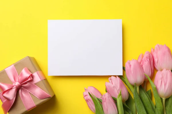 Tulipanes rosados, caja de regalo y lugar vacío sobre fondo amarillo, spac — Foto de Stock