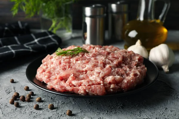 Especiarias e prato com carne picada em fundo cinza, close-up — Fotografia de Stock