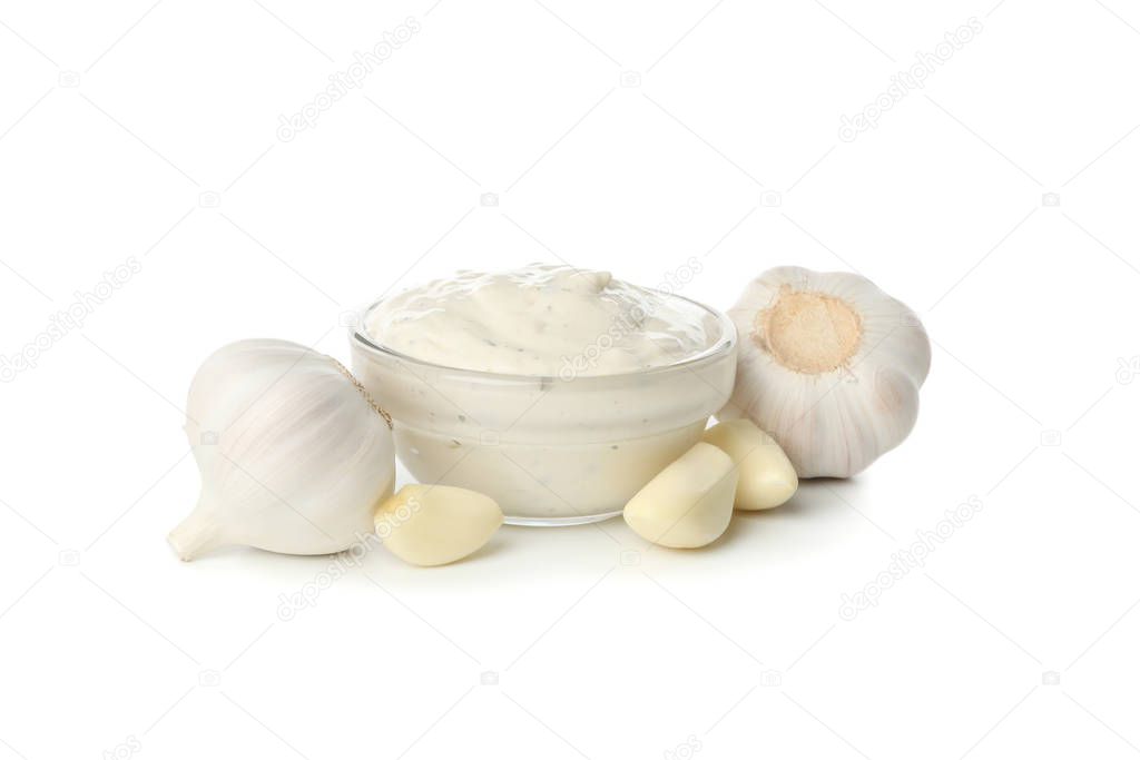 Bowl with sauce and garlic bulbs isolated on white background