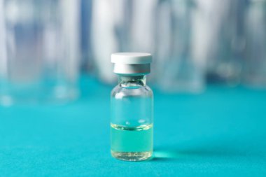 Bottle of vaccine on blue background, space for text. Virus prot