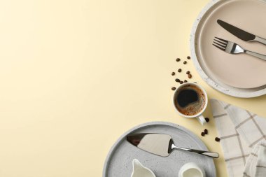 Bej arka planda bir fincan kahve ile masa ayarları, üst görünüm