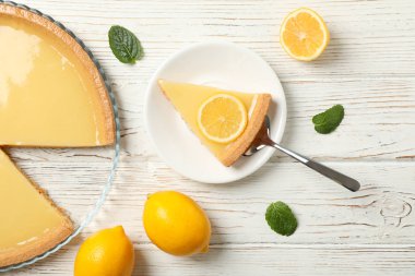 Beyaz ahşap arka planda limonlu turta kompozisyonu, üst görünüm