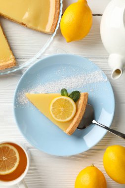 Beyaz ahşap sırtında limonlu turta dilimi ile kompozisyon