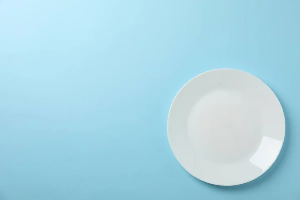 Plate on blue background, top view and space for text — 스톡 사진
