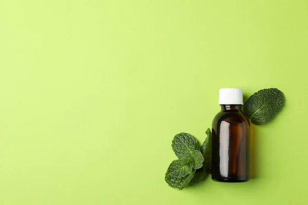 Medical bottle and mint on green background, space for text — Stock Photo, Image