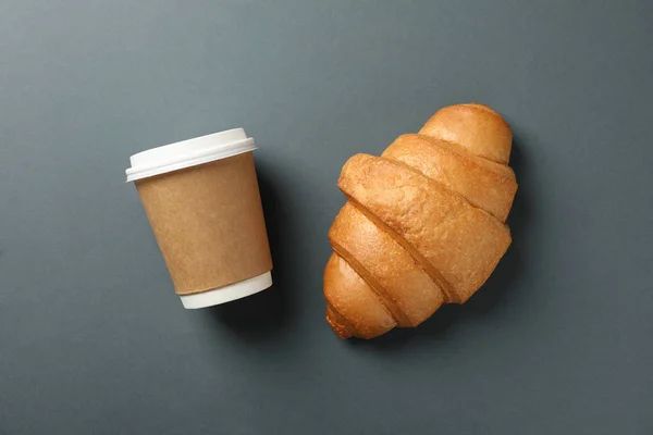Croissant y taza de papel de café sobre fondo oscuro, espacio para —  Fotos de Stock
