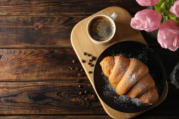 Composição com croissant saboroso no fundo de madeira, vista superior — Fotografia de Stock