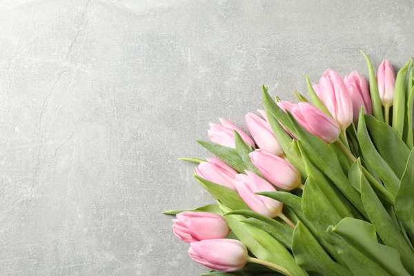 Ramo de tulipanes rosados sobre fondo gris, espacio para texto — Foto de Stock