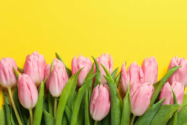 Tulipanes rosados sobre fondo amarillo, vista superior y espacio para texto — Foto de Stock