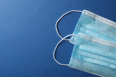 Protective mask on blue background, top view, space for text.Vir