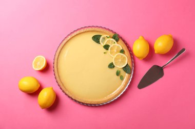 Limonlu tart, spatula ve pembe arka planda limonlar.