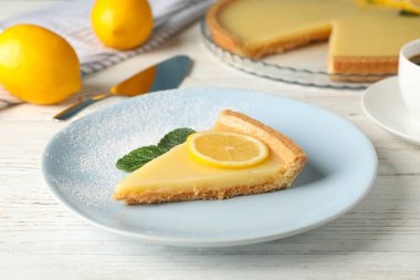 Beyaz ahşap arka planda lezzetli limonlu tart tabağı.