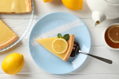 Beyaz ahşap sırtında limonlu turta dilimi ile kompozisyon