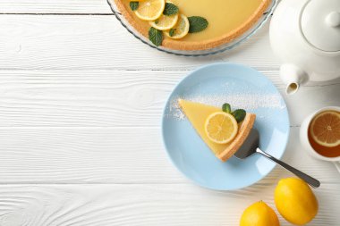 Beyaz ahşap sırtında limonlu turta dilimi ile kompozisyon