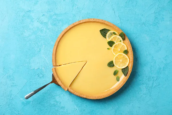 Mavi arkaplanda limonlu tart ve spatula, üst görünüm — Stok fotoğraf