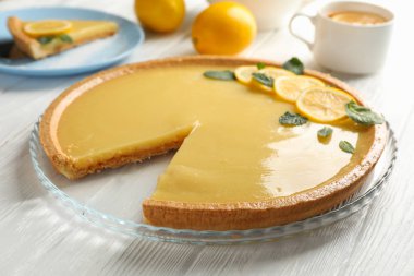 Beyaz ahşap arka planda limonlu turta kompozisyonu.