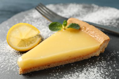 Tahta zemin üzerinde limonlu turta dilimi olan mermer tepsi tepsisi, kapat.