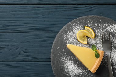 Ahşap zemin üzerinde limonlu turta dilimi olan mermer tepsi tepsisi, üst manzara