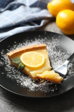 Limonlu turta dilimi ve gri arka planda havlu ve le.