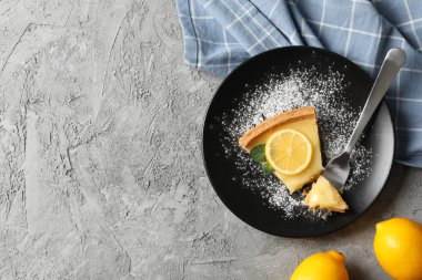 Limonlu turta dilimi ve gri arka planda havlu ve le.