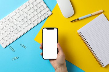 Telefonu boş ekranlı bir kadın tutuyor. İş yeri. İki - ton ba