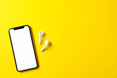 Sarı arkaplanda boş ekranlı telefon, üst görünüm