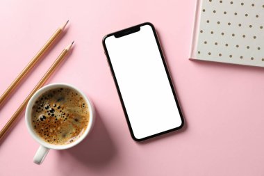 Boş ekranlı telefon, defter, kalem ve kahve. 
