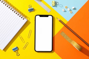 Renkli arka planda boş ekranlı telefon, üst görünüm